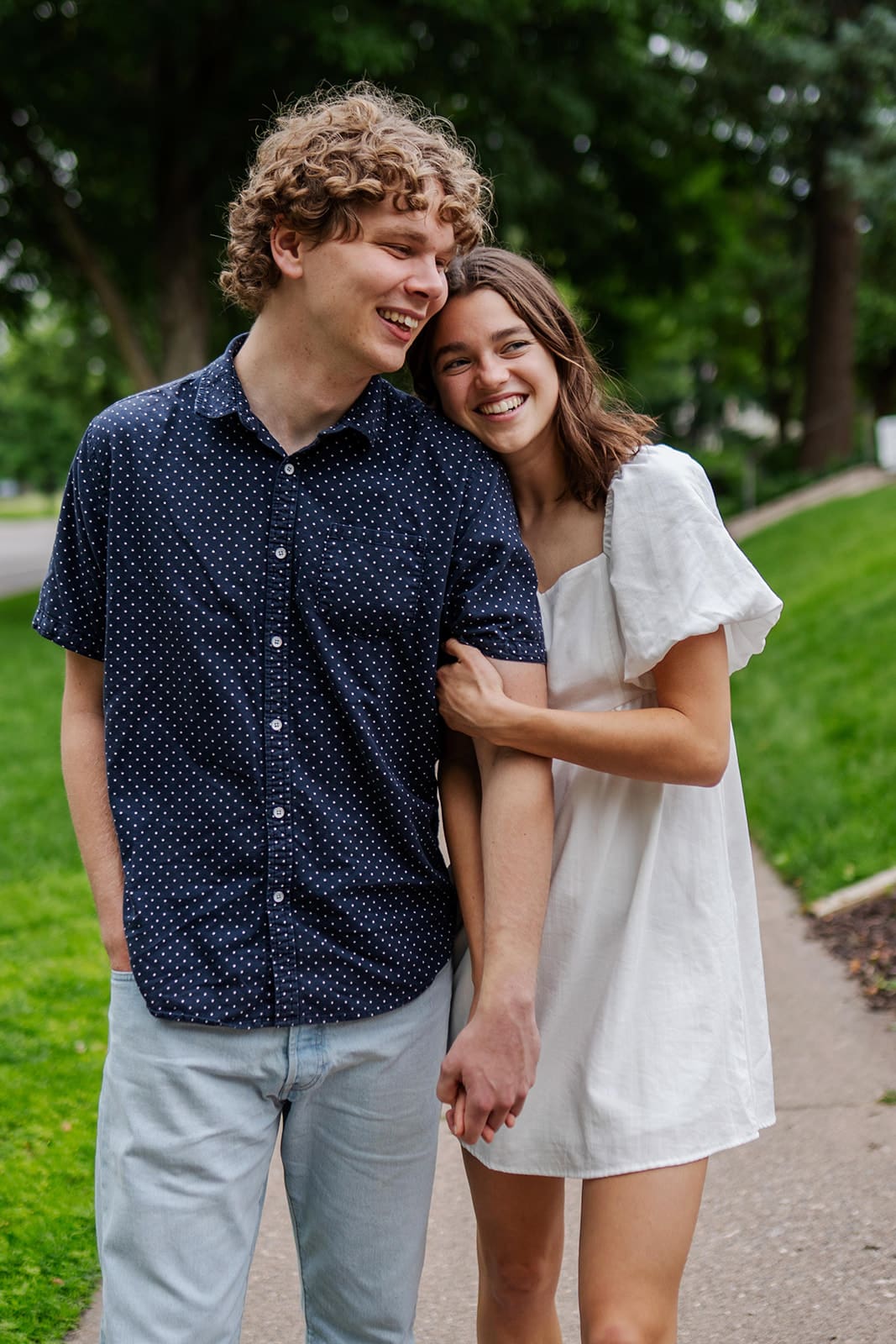 Annessa and Sam laughing together during their St Paul engagement photos near Cathedral Hill.